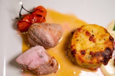 Kızarmış sığır eti ve patates ve krema soslu sebze ile servis edilen domuz eti.