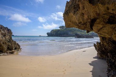 Celorio köyündeki Playa de Palombina Las Camaras 'ın manzarası, Kuzey İspanya, Asturias' ın yeşil kıyıları, kumlu plajları, kayalıkları, gizli mağaraları, yeşil tarlaları, ormanları ve dağları olan.