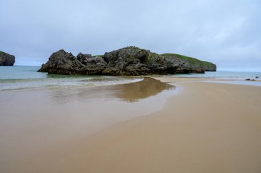Celorio 'daki Playa de Borizo' daki kayalara bakın. Kuzey İspanya, Asturias 'ın yeşil kıyıları. Beyaz kumlu plajlar, uçurumlar, gizli mağaralar, yeşil tarlalar, ormanlar ve dağlar..