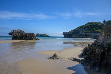 Celorio köyündeki Playa de Palombina Las Camaras 'ın manzarası, Kuzey İspanya, Asturias' ın yeşil kıyıları, kumlu plajları, kayalıkları, gizli mağaraları, yeşil tarlaları, ormanları ve dağları olan.