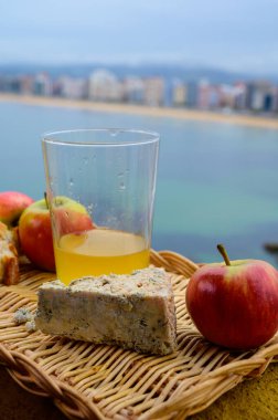 Asturias yiyecek ve içeceği, Arenas 'tan gelen mavi inek kabuğu peyniri bir bardak elma şırası ve İspanya' nın Gijon kentindeki San Lorenzo plajında manzarayla servis edildi.