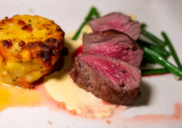 Kızarmış sığır eti ve patates ve krema soslu sebze ile servis edilen domuz eti.