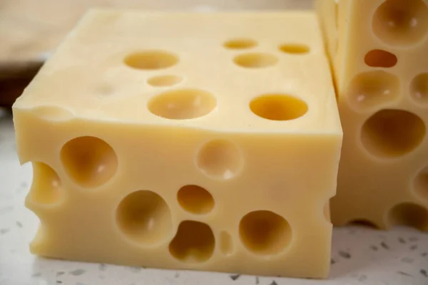 チーズコレクション 穴の開いたフランスのハードチーズのブロックメンターラーを閉じます — ストック写真
