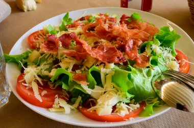 Sağlıklı yemek, taze yaz salatası yeşil salata yaprakları, salatalık, domates, peynir ve pastırma.