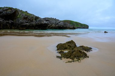 Celorio 'daki Playa de Borizo' daki kayalara bakın. Kuzey İspanya, Asturias 'ın yeşil kıyıları. Beyaz kumlu plajlar, uçurumlar, gizli mağaralar, yeşil tarlalar, ormanlar ve dağlar..