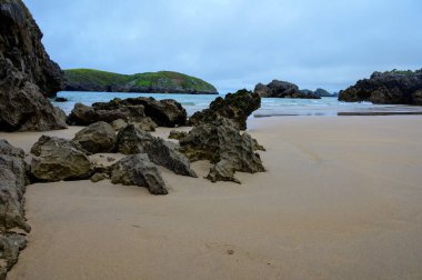 Celorio 'daki Playa de Borizo' daki kayalara bakın. Kuzey İspanya, Asturias 'ın yeşil kıyıları. Beyaz kumlu plajlar, uçurumlar, gizli mağaralar, yeşil tarlalar, ormanlar ve dağlar..