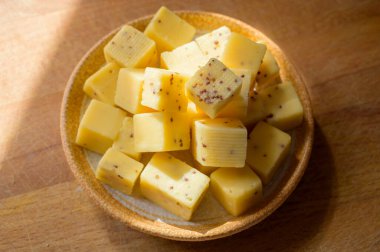 Peynir koleksiyonu, Belçika 'daki manastırdan gelen hardal tohumlarıyla olgunlaşmış sarı inek peyniri küpleri.