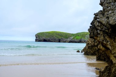 Celorio 'daki Playa de Borizo' daki kayalara bakın. Kuzey İspanya, Asturias 'ın yeşil kıyıları. Beyaz kumlu plajlar, uçurumlar, gizli mağaralar, yeşil tarlalar, ormanlar ve dağlar..