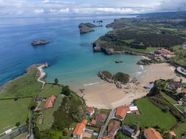 Playa de Palombina, Las Camaras ve Celorio 'daki hava manzarası, Asturias, Kuzey İspanya' nın yeşil kıyıları, beyaz kumlu plajları, kayalıkları, gizli mağaraları, yeşil tarlaları ve dağları olan.