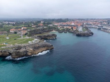 Playa de Toro 'daki hava manzarası ve eski Llanes limanı, Kuzey İspanya, Asturias' ın yeşil kıyıları kumlu plajları, uçurumları, gizli mağaraları, yeşil tarlaları, ormanları ve dağları olan.