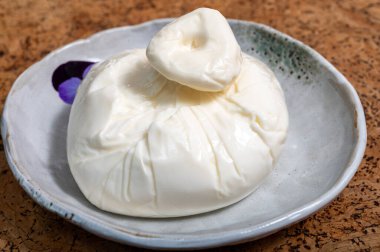 Puglia 'dan taze el yapımı İtalyan peyniri, beyaz burrata foglia saporosa topu ya da mozarella ve krema dolgusundan yapılmış burratina peyniri..