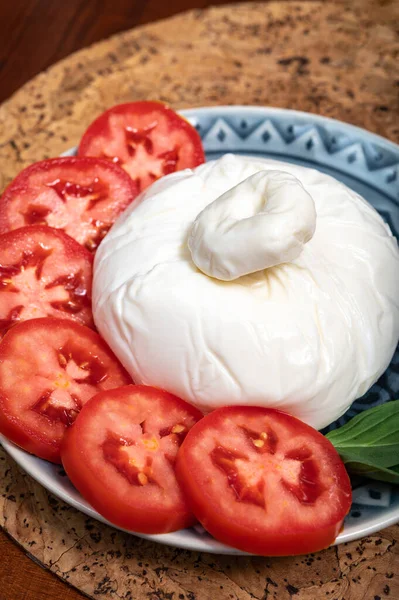 Puglia 'dan taze İtalyan peyniri, beyaz burrata foglia saporosa topu ya da mozarella ve krema ile doldurulmuş mozarella ve taze fesleğenle servis edilen burratina peyniri.