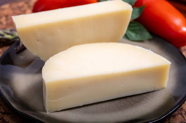 stock image Italian cheese, Provolone dolce cow cheese from Cremona served with olive bread and tomatoes close up.