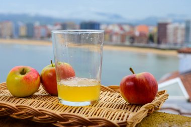 Tahta fıçıdaki mayalanmış elmalardan yapılan geleneksel Asturian şarabı hava kabarcıkları için büyük bir yükseklikten San Lorenzo sahilindeki içecek ve manzaraya dökülmelidir.