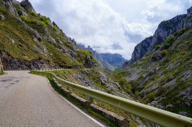 Los Arenas 'tan uzak dağ köyü Sotres' e, Picos de Europa dağlarına, Asturias 'a, İspanya' nın kuzeyine uzanan dar dağ yolu, vadi ve dağların manzarası.