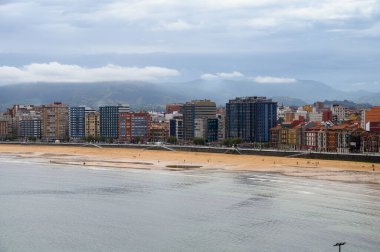 Gijon, Asturias, İspanya 'daki gezinti güvertesi, evler ve San Lorenzo plajına bakın.