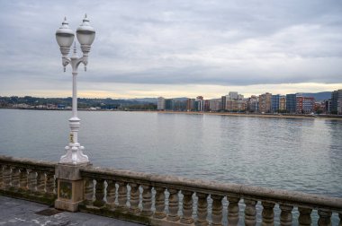 Gijon, Asturias, İspanya 'daki gezinti güvertesi, evler ve San Lorenzo plajına bakın.