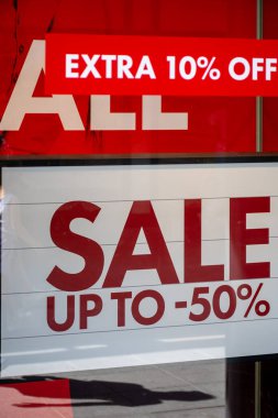 Mağazadaki yıllık indirimlerin reklamı, insanların yansıması ve alışveriş merkezleri ile cam mağaza vitrininde satış hakkında bilgiler.