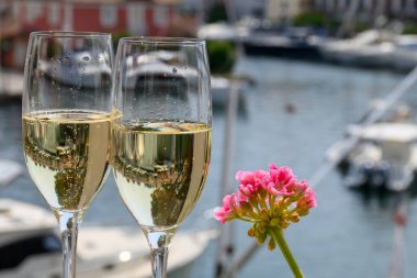 Fransız brüt şampanyası bardaklarda köpüklü şarap içmek, Saint-Tropez yakınlarındaki Port Grimaud limanında kulüp partisi, Fransız Riviera tatili, Var, Fransa
