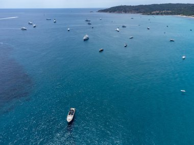 Botlardaki hava manzarası, Saint-Tropez yakınlarındaki efsanevi Pampelonne sahilinin kristal berrak mavi suyu, Fransız Riviera, Var, Fransa 'nın beyaz kumlu plajında yaz tatili