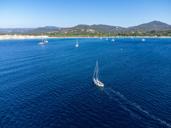Aerial view on blue water of Gulf of Saint-Tropez, sail boats, beaches and houses of Port Grimaud, Port Cogolin, summer vacation in Provence, France