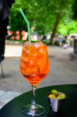 Garson Aperol Sprits yaz kokteylini Aperol, Prosecco, buz küpleri, tonik su ve portakalla hazırladı, güneşli terasta içmeye hazır.