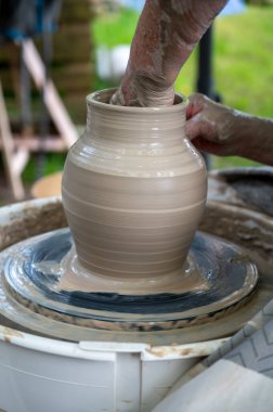 Hollanda 'da atölye çalışması sırasında çömlekçi çarkında çamur tenceresi yapmak