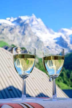Savoy bölgesinden gelen beyaz Roussette de Savoie ve Vin de Savoie Fransız şarabı içerken yaz aylarında Hautes Alpes dağlarının zirvesinde kar manzaralı.