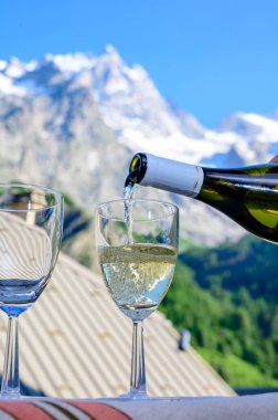 Savoy bölgesinden gelen beyaz Roussette de Savoie ve Vin de Savoie Fransız şarabı içerken yaz aylarında Hautes Alpes dağlarının zirvesinde kar manzaralı.