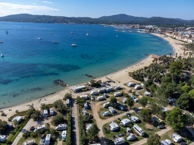 Saint-Tropez Körfezi 'nin mavi sularındaki Arial manzarası, kumlu plaj, Port Grimaud' daki evler, Akdeniz kıyısındaki yatlı köy, Provence, Fransa 'da yaz tatili..