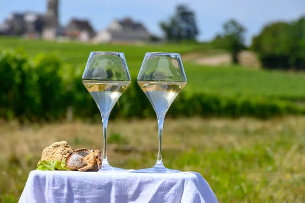 stock image Glasses of white wine from vineyards of Pouilly-Fume appelation and example of flint pebbles soil, near Pouilly-sur-Loire, Burgundy, France.