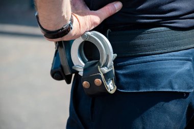 Polis memuru, kemerinde kelepçe olan polis memuru, iklimi önleme, yakın plan