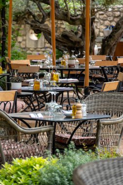 Öğle yemeğinden önce, boş şık kafeler servis masaları ile güneşli Saint-Tropez, Provence 'de misafirleri bekliyor.