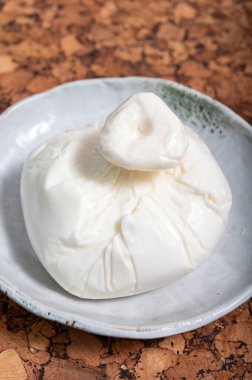 Puglia 'dan taze İtalyan peyniri, beyaz burrata foglia saporosa topu ya da mozarella ve kremadan yapılmış burratina peyniri.