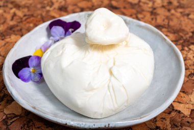Puglia 'dan taze İtalyan peyniri, beyaz burrata foglia saporosa topu ya da mozarella ve kremadan yapılmış burratina peyniri.