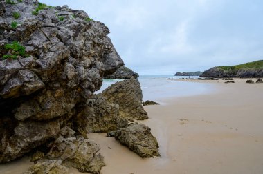 Celorio 'daki Playa de Borizo' daki kayalara bakın. Kuzey İspanya, Asturias 'ın yeşil kıyıları. Beyaz kumlu plajlar, uçurumlar, gizli mağaralar, yeşil tarlalar, ormanlar ve dağlar..