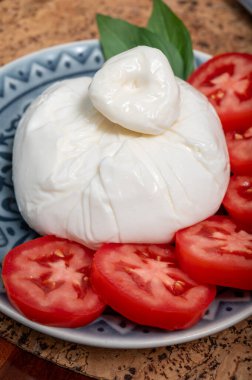 Puglia 'dan taze İtalyan peyniri, beyaz burrata foglia saporosa topu ya da mozarella ve krema ile doldurulmuş mozarella ve taze fesleğenle servis edilen burratina peyniri.