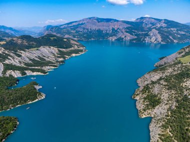 Serre-Poncon 'un mavi gölü üzerindeki hava manzarası, Hautes-Alpes ve Haute-de-Haute Provence departmanları arasındaki rezervuar sınırı, Batı Avrupa' nın en büyük bölümlerinden biri.