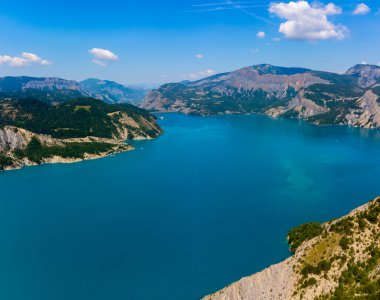 Serre-Poncon 'un mavi gölü üzerindeki hava manzarası, Hautes-Alpes ve Haute-de-Haute Provence departmanları arasındaki rezervuar sınırı, Batı Avrupa' nın en büyük bölümlerinden biri.