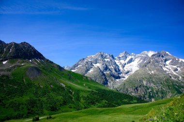 Dağlar ve yeşil alp çayırları Col du Lautaret, Massif des Ecrins, Hautes Alpes, Fransa yakınlarındaki yazlık alanları