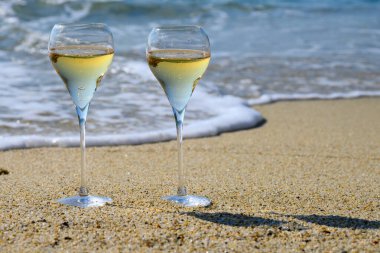 Provence 'de yaz zamanı, iki bardak soğuk şampanya. Güneşli bir günde Saint-Tropez yakınlarındaki kumlu plajda köpüklü şarap. Var Bölümü, Fransa' da tatil.