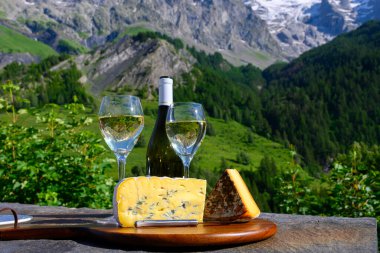 Peynir ve şarap, Savoy bölgesinden beyaz Roussette de Savoie ve Vin de Savoie şarabı ve üstünde karlı Hautes Alpes Dağları manzaralı.