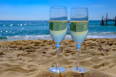 Provence 'de yaz mevsimi, iki bardak soğuk şampanya krep şarabı güneşli bir günde Saint-Tropez yakınlarındaki ünlü Pampelonne kumlu plajında, Var Bölümü, Fransa' da vanation