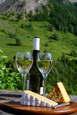 Peynir ve şarap, Savoy bölgesinden beyaz Roussette de Savoie ve Vin de Savoie şarabı ve üstünde karlı Hautes Alpes Dağları manzaralı.