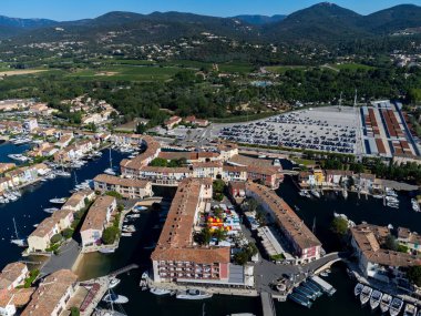 Saint-Tropez Körfezi 'nin mavi suları, tekneler, Port Grimaud ve Cogolin' deki evler, Akdeniz 'deki yatlı köyler, Provence, Fransa' da yaz tatili.
