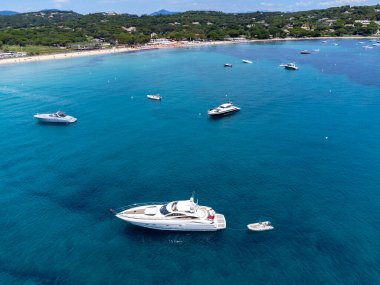 Botlardaki hava manzarası, Saint-Tropez yakınlarındaki efsanevi Pampelonne sahilinin kristal berrak mavi suyu, Fransız Riviera, Var, Fransa 'nın beyaz kumlu plajında yaz tatili
