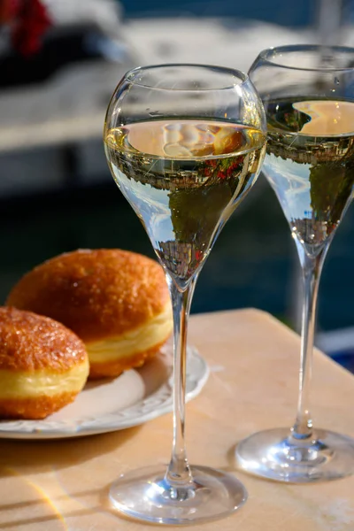 stock image Drinking of French brut champagne sparkling wine with sweet apple Beignet cake, club party in yacht harbour of Port Grimaud near Saint-Tropez, French Riviera vacation, France