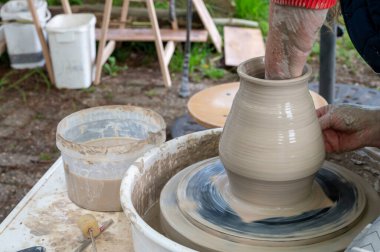 Hollanda 'da atölye çalışması sırasında çömlekçi çarkında çamur tenceresi yapmak