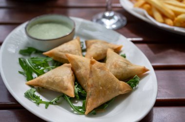 Geleneksel Orta Doğu atıştırmalıkları nane soslu doldurulmuş sebzeli samosa turtaları.