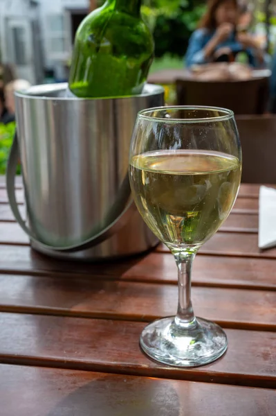 Drinking cold white wine with friends on outdoor terrace, summer vacation, close up